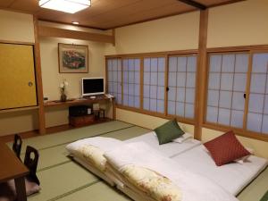 מיטה או מיטות בחדר ב-Ryokan Sawaya Honten