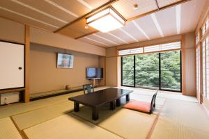 a large room with a table and a tv at Hotel Ogawa in Asahi