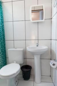 ein weißes Badezimmer mit Toilette und Waschbecken in der Unterkunft Pousada & Kitnet Nascer do Sol in Ilha de Boipeba + 45 Fotos