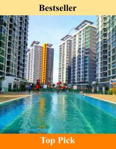 une grande piscine en face de certains grands bâtiments dans l'établissement Shah Suites Vista Alam, à Shah Alam