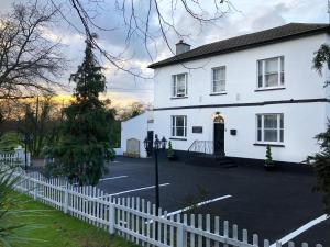 a white house with a white picket fence at STIFFORD CLAYS FARM HOTEL in North Stifford