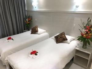 维拉港Central Bay Motel的两张位于酒店客房的床,上面有鲜花