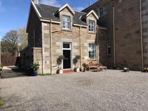 una casa con una entrada de grava delante de ella en Newfield Mews en Ayr