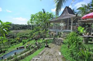 uma casa com um lago em frente a um jardim em Bali Lush em Selemadeg