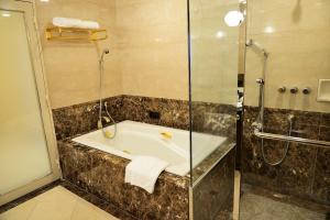 a bathroom with a shower, sink, and tub at Rihga Royal Hotel Hiroshima in Hiroshima