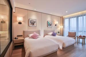 a hotel room with two beds and a window at SSAW Boutique Hotel Wenzhou Jiushan Lake in Wenzhou