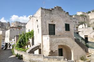 un vieux bâtiment en pierre sur le côté d'une colline dans l'établissement Agli Archi Dimore Storiche, à Matera