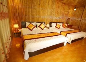 Duas camas num quarto com paredes de madeira em Tuan Ngoc Hotel em Ninh Binh