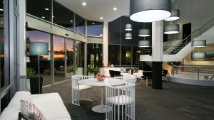 a lobby with a white table and white chairs at Best Western Plus Apollo International in Newcastle