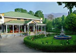 un edificio con fontana in mezzo a un giardino di WelcomHeritage Taragarh Palace a Kangra