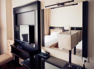 a hotel room with a bed and a mirror at Hotel S Damansara in Kuala Lumpur