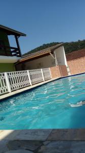a swimming pool in front of a house at Montanhas Bem Te Vi in Caraguatatuba