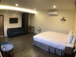 a hotel room with a bed and a couch at 800 Lan Homestay in Zhushan