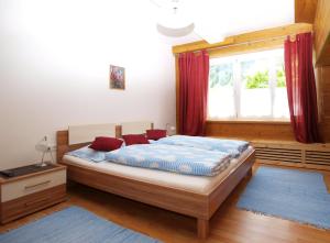 een slaapkamer met een bed met rode gordijnen en een raam bij Ferienwohnung Mondial in Neustift im Stubaital