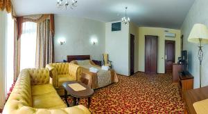 ハバロフスクにあるホテル コンプレックス ベルサイユのベッドとソファ付きのホテルルーム