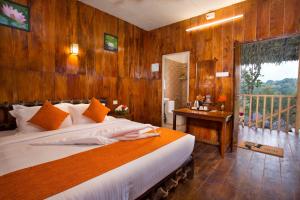 a bedroom with a large bed and a balcony at Spices Lap, Thekkady in Thekkady