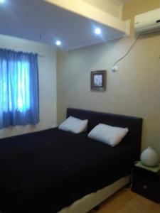 1 dormitorio con 1 cama con 2 almohadas y ventana en Maria's House nearby Victory Town Center en Kay Riapay