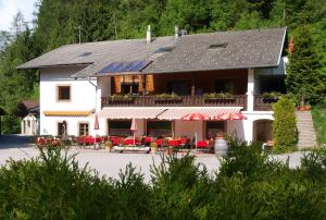 un grande edificio bianco con tavoli e sedie rossi di Ferienwohnung Kirchbrücke a Mieders