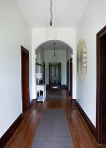 un corridoio con pareti bianche, pavimenti in legno e una porta di The Bower Mudgee a Mudgee