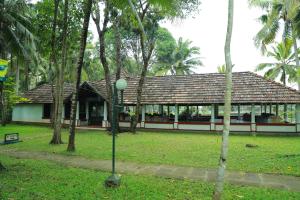 a building in the middle of a park with trees at The Windsor Castle in Kottayam