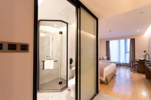 a bathroom with a glass shower in a hotel room at Ramada Plaza Wyndham Wenzhou Cangnan in Wenzhou