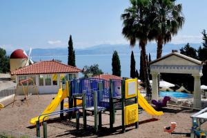 um parque infantil com um escorrega amarelo e um controle deslizante em Louis Ionian Sun em Agios Ioannis Peristerion