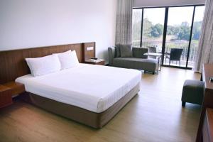 a hotel room with a bed and a chair at The Bayview Beach Resort in Batu Ferringhi