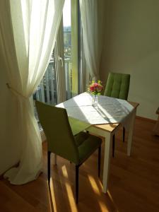 a dining room table with a vase of flowers on it at Quellenresidenz Bad Vilbel in Bad Vilbel
