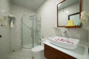 y baño con lavabo, ducha y aseo. en Quang Tung Hotel, en Cat Ba