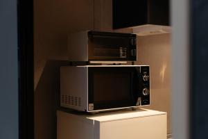 two microwaves are stacked on top of each other at 礎旅音 in Kanazawa