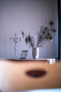 a cross and a vase with flowers on a shelf at Delux apartment Moj Osijek, SELF CHECK-IN in Osijek