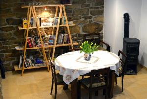 una mesa en una habitación con chimenea y estantería en Dom Coacha i Mentora, en Wysowa-Zdrój
