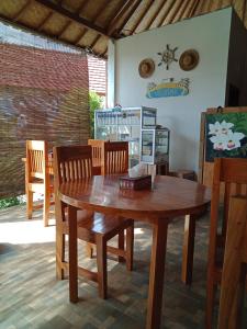 a wooden table and chairs in a room at The Umah Prahu in Nusa Penida