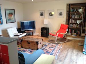 a living room with a tv and two chairs at Cutty Sark Cottage in Kirkton of Largo