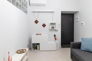 ein Wohnzimmer mit weißen Wänden und einem Sofa in der Unterkunft Casa Gabry in Pozzuoli