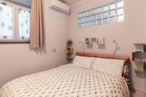 a bedroom with a bed with a comforter and two pillows at Casa Gabry in Pozzuoli