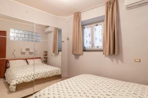 a bedroom with two beds and a window at Casa Gabry in Pozzuoli