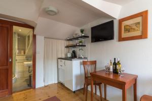 uma cozinha com uma mesa e uma cozinha com uma televisão em Apartments Ivana em Dubrovnik