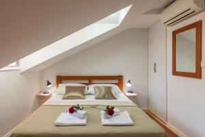 een slaapkamer met een groot bed en 2 handdoeken bij Apartments Ivana in Dubrovnik