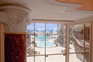 a room with a view of a pool through a window at Golden Rainbow Beach Hotel in Sunny Beach