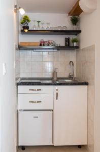 a kitchen with white cabinets and a sink at Apartments Ivana in Dubrovnik
