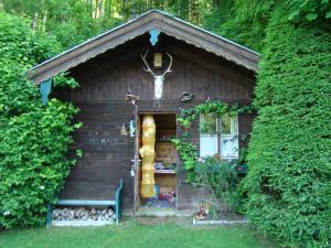 małą drewnianą kabinę z drzwiami i oknem w obiekcie Landhaus Teufl w mieście Faistenau