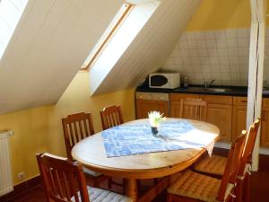 a kitchen with a wooden table with chairs and a window at Ostsee-Ferienoase-3-Raum-App-Typ-1 in Klütz