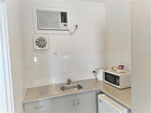 a kitchen with a sink and a microwave at Glenelg beach gateway on Moseley in Glenelg