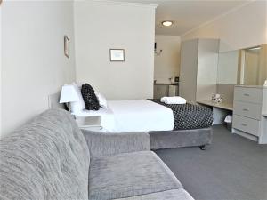 格莱内尔格Glenelg beach gateway Studio Apartment的配有床和沙发的酒店房间