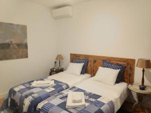 2 Betten in einem Zimmer mit 2 Bettlaken und einem Buch in der Unterkunft Casa do Passadiço in Lissabon