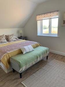 a bedroom with a large bed and a window at The Piggery in Chichester