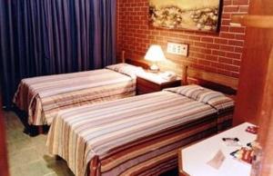 A bed or beds in a room at Estancia Park Hotel