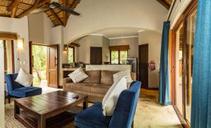 uma sala de estar com um sofá e uma mesa em Raptors Lodge em Hoedspruit