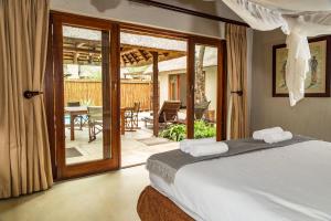 una camera con letto e un patio con tavolo di Raptors Lodge a Hoedspruit Altre 28 foto